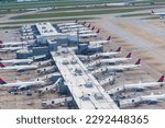 Small photo of Atlanta, GA, USA - April 16, 2023: Aerial view of Concourse B building of Hartsfield-Jackson Atlanta International Airport and apron with many Delta airlines airplanes from ascending plane
