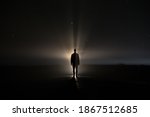 backlighting of a man in the dark of a foggy night and a light behind the model