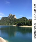 Small photo of Portrait image of le tache mountain peak towering up behind the alpine Lac de Taney, under a clear blue sky, on route to Le Grammont summit. Valais, Switzerland, Summer 2018