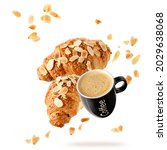 Small photo of Fresh baked almond breakfast croissants with nuts flakes crumbs and black cup hot espresso coffee flying isolated on white background. Two croissants and cup falling. Pastry shop or cafe card.