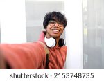 Small photo of Asian adolescent male taking selfie with phone looking at camera. Teen boy college students take photo of himself.