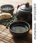 Small photo of Ginseng tea brew and ginseng root . Ginseng Oolong tea brew and cup of ginseng oolong tea on a wooden table.