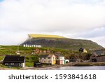 Small photo of Nolsoy island panoramic photo with sign "Nollywood" on a hill and colorful houses. Faroe Islands, Denmark.