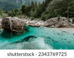 Emerald turquoise water of Soca river in Slovenia.Rafting and kayaking place in Europe. Wonderful Soca gorge in green forest near Bovec.Summer outdoor activities.Crystal clear water
