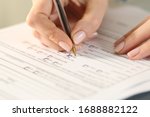 Close up of woman hands filling form crossing yes checkbox on a desk