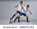 Small photo of two soccer players interfere with each other, compete. studio portrait of young football players
