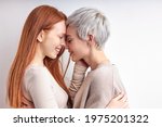Side View Portrait Of Pretty Redhead Woman And Short Haired Lady Hugging, Feeling Love, Standing Closely To Each Other, Enjoying Time Together, Smiling Happily. LGBT, Lesbians, lgbt couple