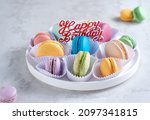 Macaron or macaroon birthday cake on white plate isolated on white background. Sweet and colorful dessert.