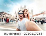 Happy couple taking selfie in front of Duomo cathedral in Milan, Lombardia - Two tourists having fun on romantic summer vacation in Italy - Holidays and traveling lifestyle concept
