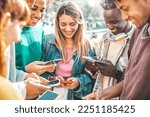 Happy group of multiracial teens using smart mobile phone outdoors - Diverse university students watching smartphones in college campus - Millenial people having fun on city street - Youth culture 