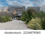 Small photo of London, England-August 2022; Low angle view over the elevated parkway between Kings Cross and Granary Square and Gasholder Park with both new development and historic buildings of Coal Drops Yard