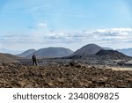 Small photo of Standing woman overlooking lavafield near mountain Fagradalsfjall with fissure vent of 2021 in Geldingadalir volcano area to the south of Fagradalsfjall mountain, Iceland