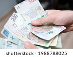 The Man Holds Polish Zlotys In...