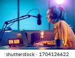 Small photo of Young radio host working in the studio, she is smiling and broadcasting announcements