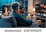 Small photo of Friends choosing a movie to watch together at home, video on demand concept