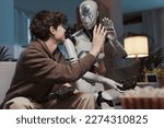 Small photo of Happy boy and AI robot giving a high five, they are playing videogames together at home, human-robot interaction concept