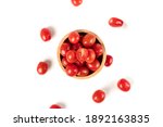 Top view of cherry tomatoes in a wooden bowl isolated on white background