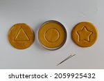 Small photo of Top view Dalgona or Ppopgi candy, honeycomb toffee sugar candy with round, star and triangle shape on white background
