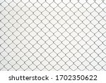 Chain link fence. Steel wire mesh isolated on white wall background.