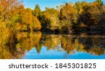 Small photo of BOISE, IDAHO - OCTOBER 30, 2020: A quiet pond bordered by colorful tress during the fall lighted by the morning sun in Kathryn Albertson's Park.