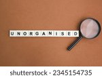 Small photo of magnifying glass and letters of the alphabet with the word Unorganized. unorganized concept. something is out of order