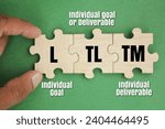Small photo of wooden puzzle with letters L, TL and TM. Individual Accountability. individual goal, Individual Goal or Deliverable and individual Deliverable