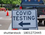 Small photo of Covid testing sign on a barricade in the street in Florida.