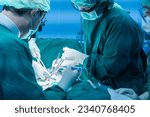 Small photo of Medical team of surgeons in hospital working surgical intervention.Surgery operating room with electrocautery equipment for breast cosmetic.Surgeon gloved hands hold the instrument