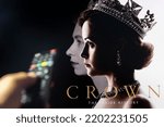 Small photo of Belgrade, Serbia - September 12, 2022: Watching TV Show The Crown on Netflix with remote control in hand. TV series is about British Royal family and Queen Elizabeth II.