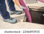 Small photo of PLUMBER UNCLOGGING, DRAINING AND CLEANING SEWER MANHOLE. CLOGGING PROBLEMS DUE TO FLUSHING WET WIPES DOWN THE TOILET. HOME INSURANCE CONCEPT.