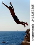 Small photo of Dubrovnik, Croatia - Sept. 9, 2023: Daredevil divers take the plunge into the Adriatic Sea from the famous cliffside Buza Bar on the steep slope of Dubrovnik's iconic fortified Old Town.