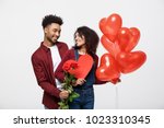 Young attractive african american couple on dating with red rose,heart and balloon.