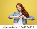 Lifestyle Concept: Beautiful attractive woman in denim making a heart symbol with her hands