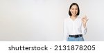 Small photo of Very good. Smiling asian woman showing okay with satisfied face expression, praise and compliment great job, pleased by smth, standing over white background