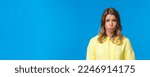 Small photo of Close-up portrait cute gloomy and upset sulky blond girl with short haircut, sobbing and pouting frowning distressed, offended being rejected or let down, standing blue background.