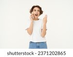 Small photo of Portrait of chatty young woman, talking on mobile phone and gesturing, discussing something over the telephone conversation, standing over white background.