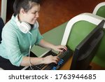 Small photo of Asian young blind person woman with headphone using computer with refreshable braille display or braille terminal a technology device for persons with visual disabilities.