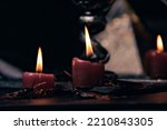 Small photo of Witchcraft composition with burning candles, jewelry and pentagram symbol. Halloween and occult concept, black magic ritual.