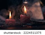Witchcraft composition with burning candles, books, jewelry and pentagram symbol, occult concept, black magic ritual.