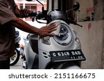 Small photo of The motorcycle is being washed or sepeda motor merk honda jenis scoopy berwarna putih sedang dibersihkan dan dicuci. Central Java, Indonesia, April 30, 2022