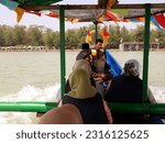 Small photo of The people is riding the boat on the beach. Indonesia, June 12, 2023, pengunjung wisata pantai widuri pemalang, sedang naik perahu nelayan dengan biaya ride a fishing boat, as a tourist destination