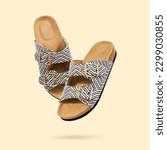 Small photo of Summer Vegan cork sandals with double straps flying on a beige background. Fashionable female trendy slippers. Eco-friendly natural shoes. Cut out objects for design, Creative concept. Copy space.
