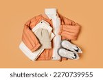 Stylish terracotta children's autumn jacket with knitted sweater, trousers and boots. Fashion kids outfit for for spring, autumn or winter. Flat lay, top view
