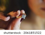 Small photo of Solitaire ring, young girl in red nail polish holding solitaire ring, close up view
