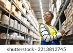 Small photo of Young woman Store manager holding tablet and checking inventory in the warehouse store.Portrait African staff, product counting Warehouse Control Manager Standing, counting and inspecting products.