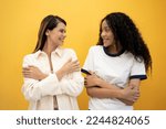 Small photo of International Woman day power African American European friend . Lesbian couple woman huge embraces equity herself, fulfilled, has high self esteem, smiling isolated on yellow background.