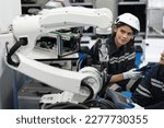Small photo of Engineer caucasian woman use tablet computer checking arm robot in the machine lap