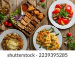 Small photo of platter of different kebabs, pilaf with beeg, khachapuri with cheese, adjabsandali top view on wooden table