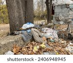 Small photo of Illegal road dump with supermarket trolley full of trash and other rubbish bag, toys and autumn golden leaves, fly dumping, fly tipping (UK), dumping of waste illegally, authorised rubbish dump