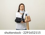 Small photo of Depressed woman suffering from pain. Broken arm and leg. woman put on plaster cast splint with walking sticks crutches. Patient wearing sling support arm with neck collar. life insurance and accident